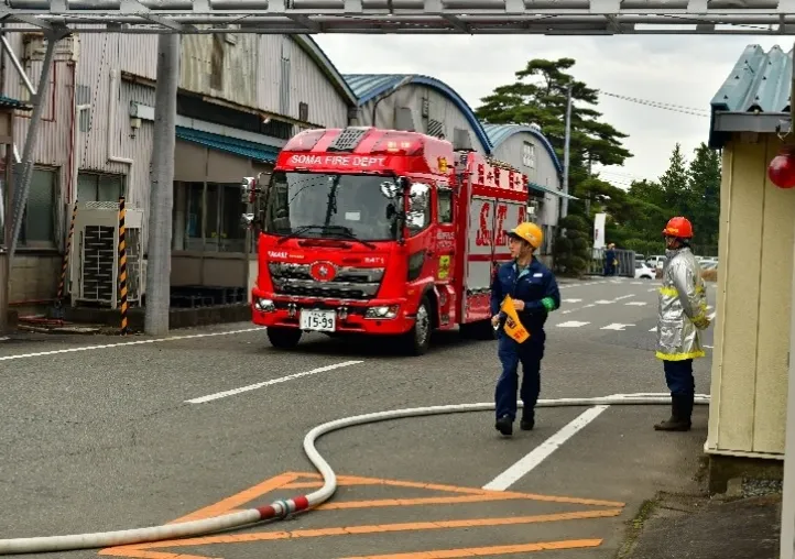 緊急事態対応の訓練で消防車が到着している写真